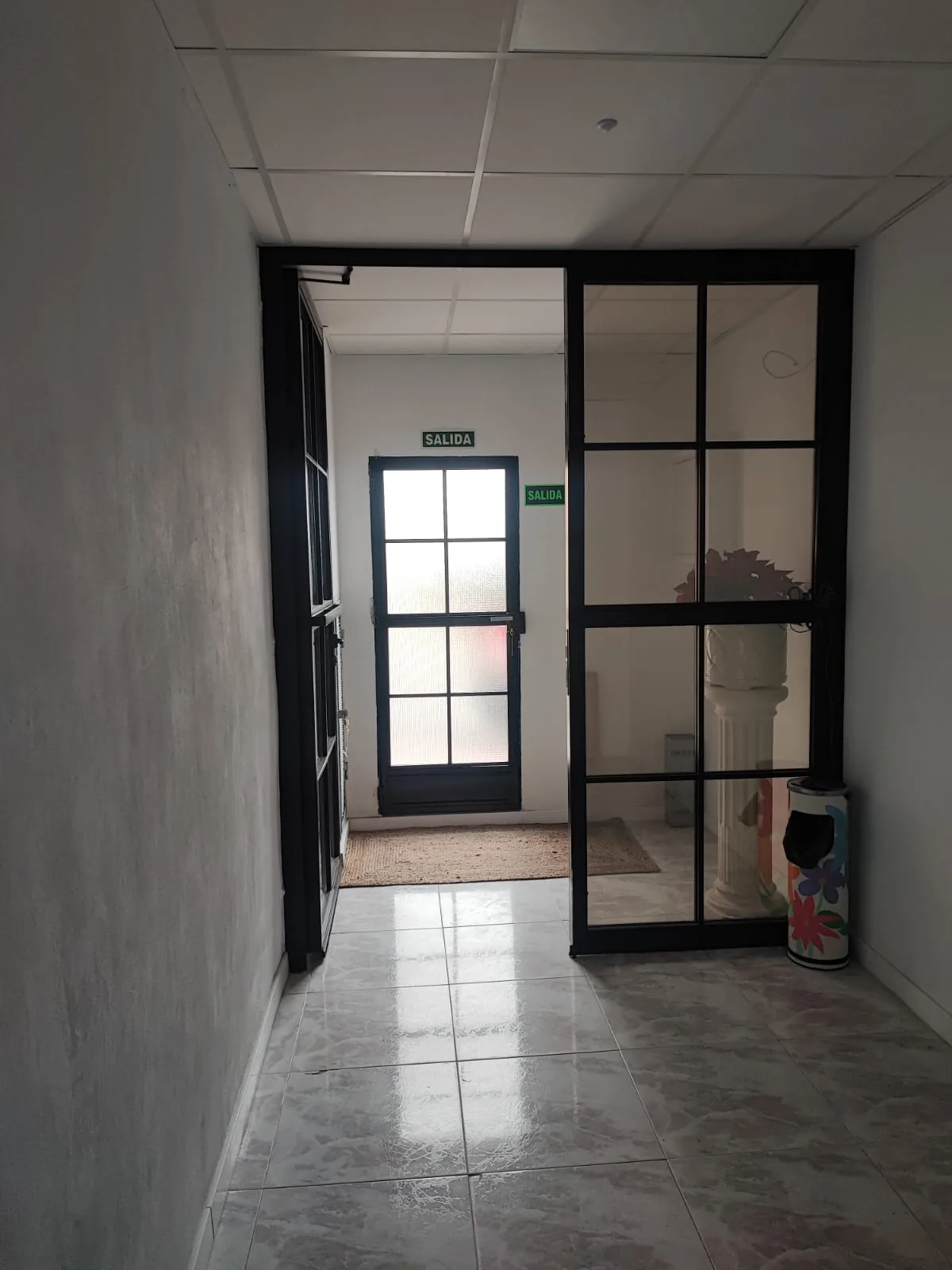 Recibidor con puerta acristalada de perfil negro